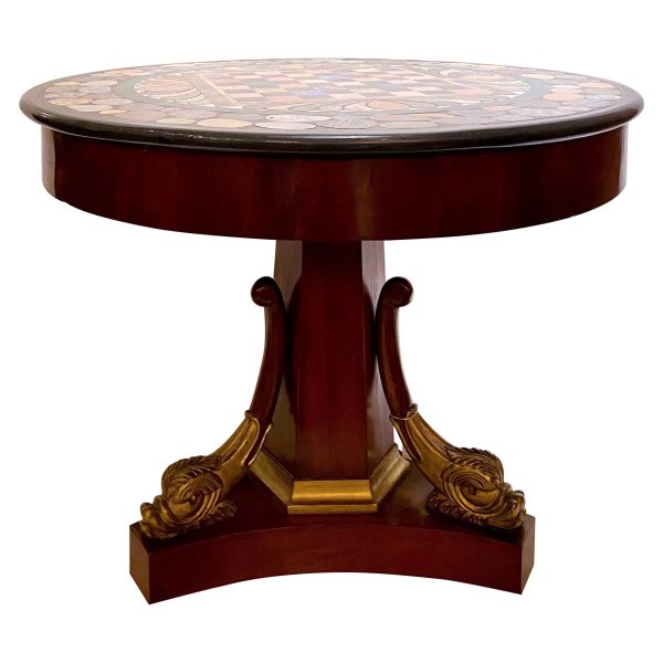 A round pedestal table with a marble top and elegant gold accents.