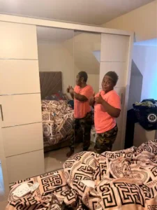 Happy Climax Furniture customer giving thumbs up next to her new Oslo Sliding Mirror Wardrobe 203cm