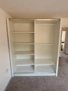Oslo Sliding Mirror Wardrobe 180cm in White without three panel sliding doors and central mirror, installing in a bedroom. Delivered by Climax Furniture UK (1)