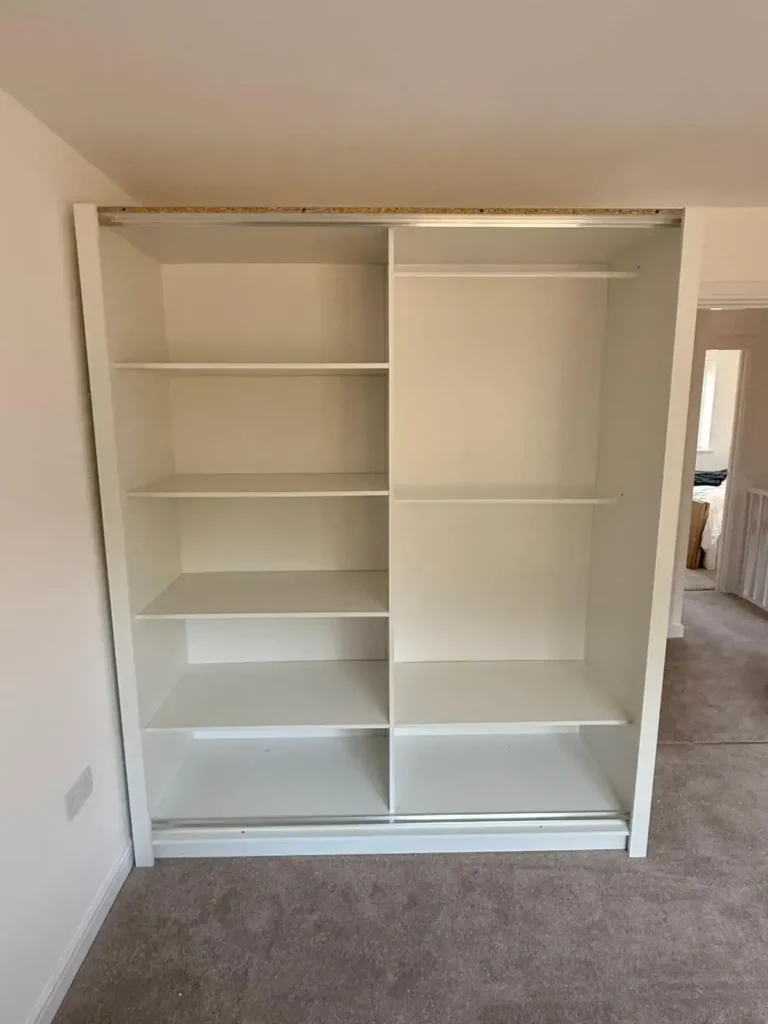 Oslo Sliding Mirror Wardrobe 180cm in White without three panel sliding doors and central mirror, installing in a bedroom. Delivered by Climax Furniture UK (1)
